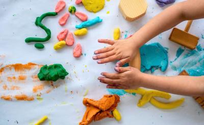 child hand playing with playdough