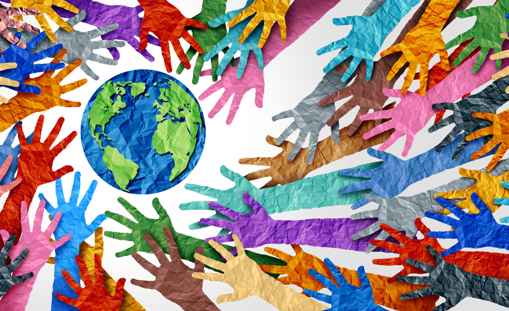 White background with paper cut multi color hands reaching out to circle the earth.