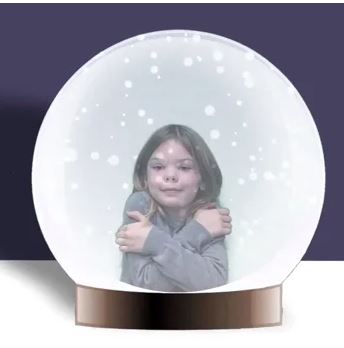 Photo of young girl inside of a cartoon snowglobe.